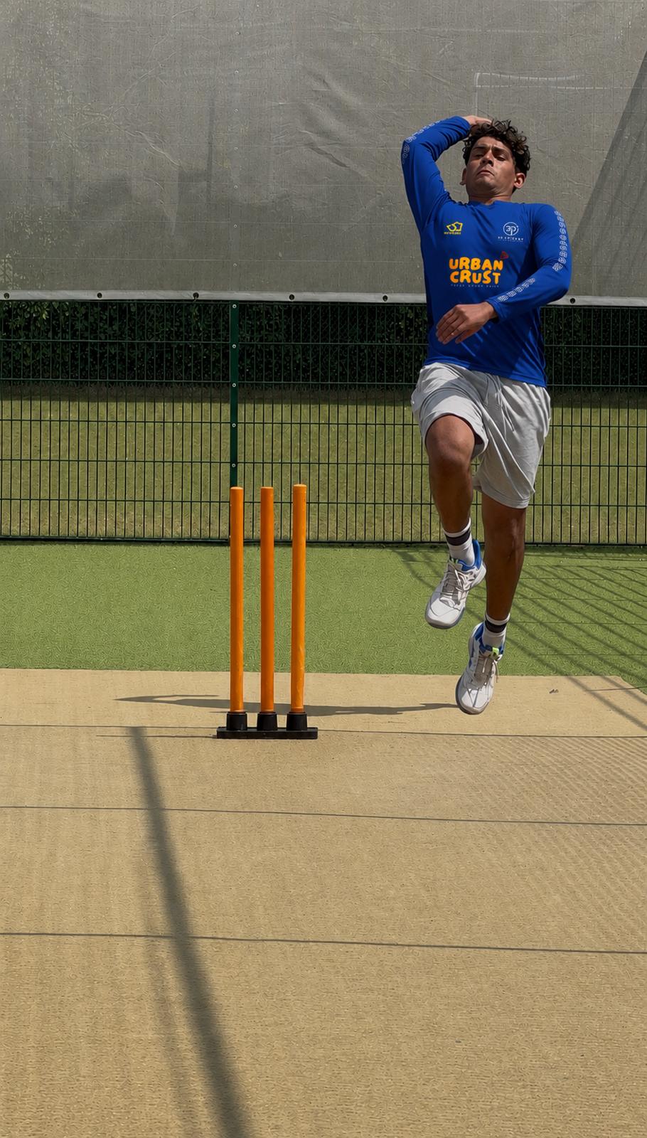 Indoor cricket net session in progress.